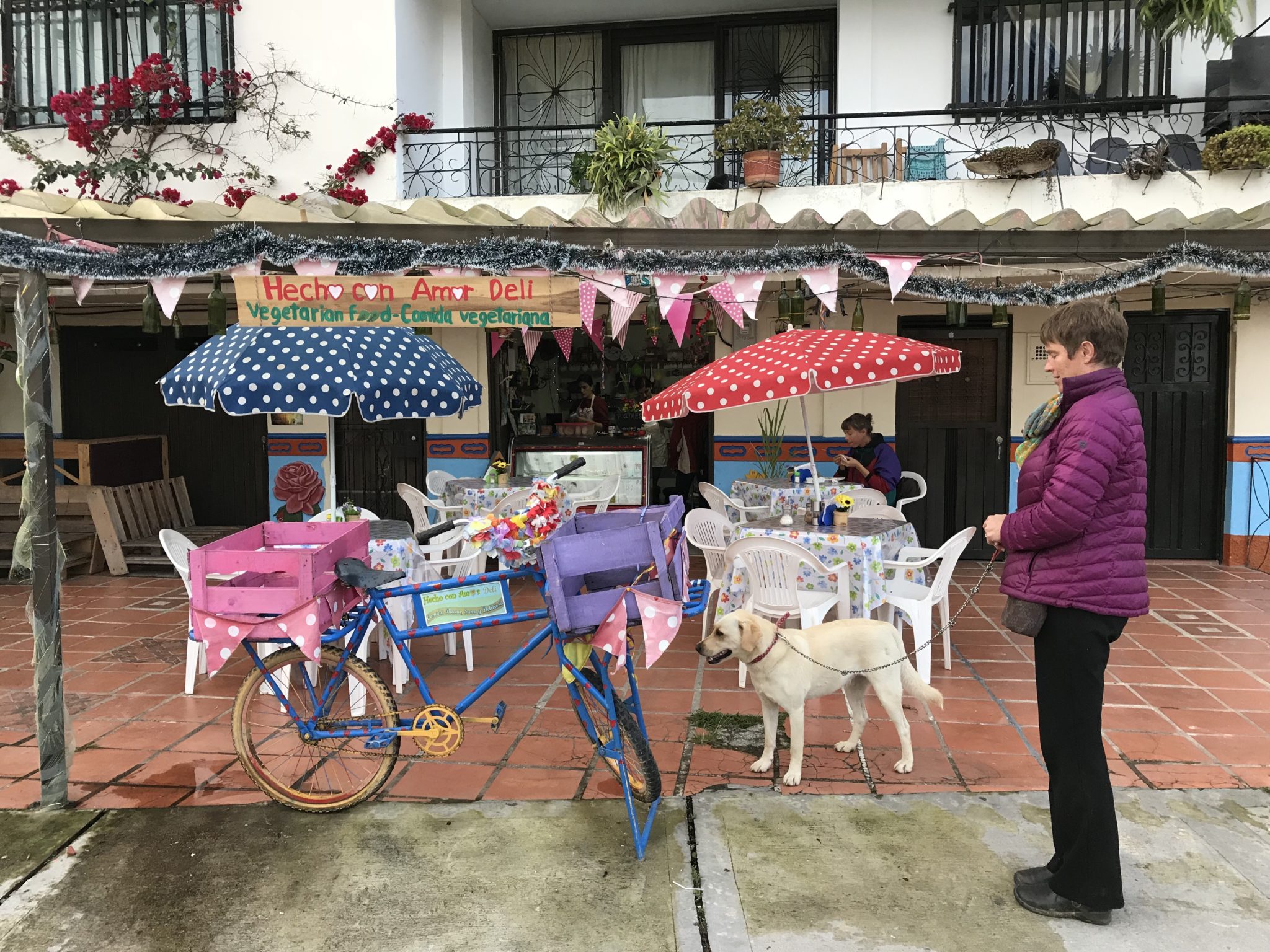 Leigh holds Bella in front of Hecho Con Amor Deli in Guatapé