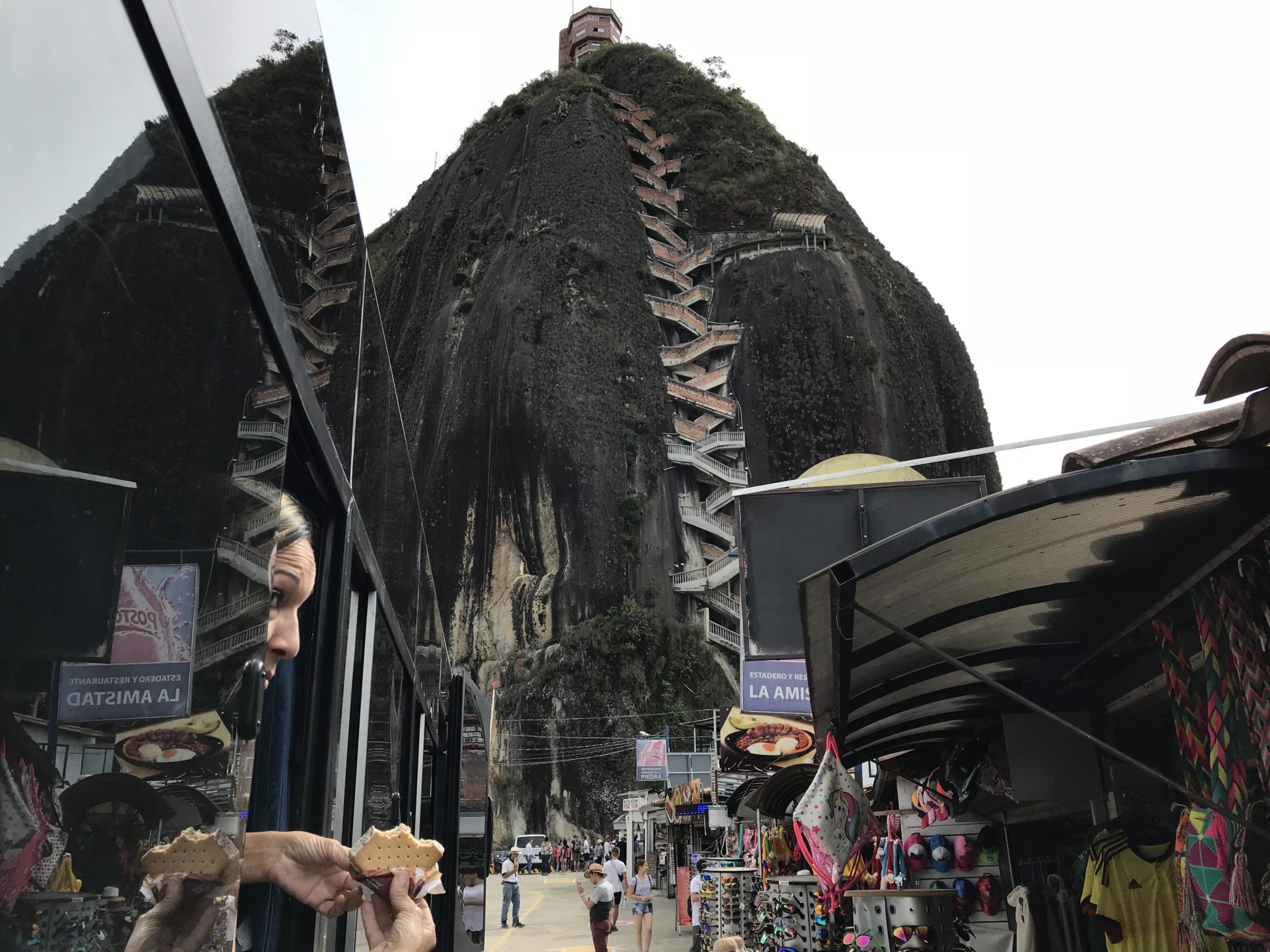 The rock of El Peñol and it's crazy stairs with reflection in a tour bus