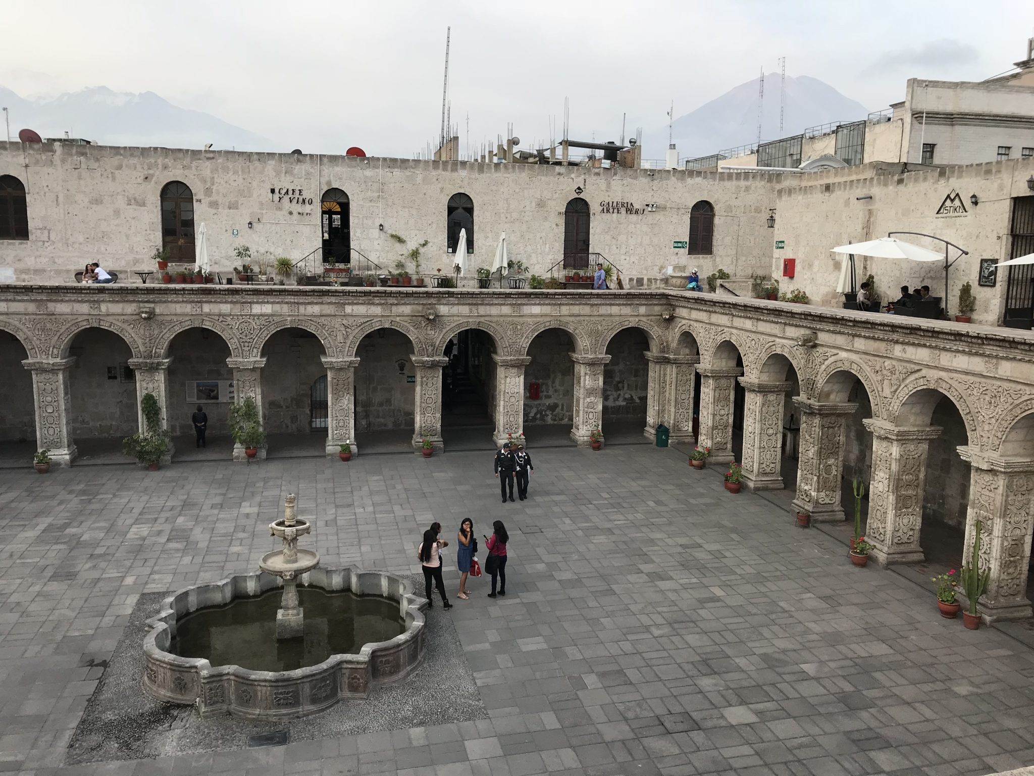 Volcanoes loom over the courtyard of the Cloisters of the Company, Arequipa, Peru